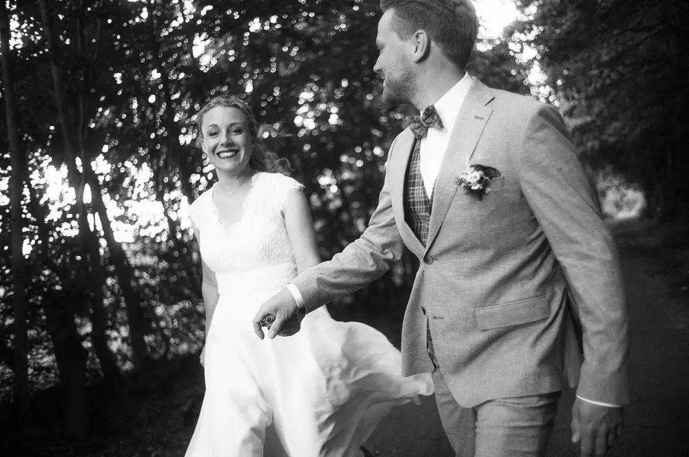 Hochzeitspaar läuft durch eine Allee in Elmshorn. Schwarzweiß-Foto. Leica Vintage Style. Leica M10 M11.